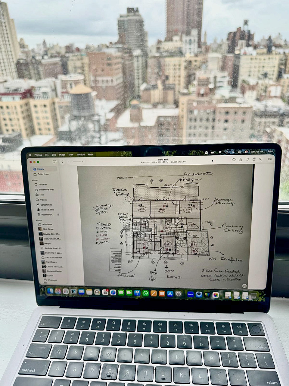 laptop with floor plans by window